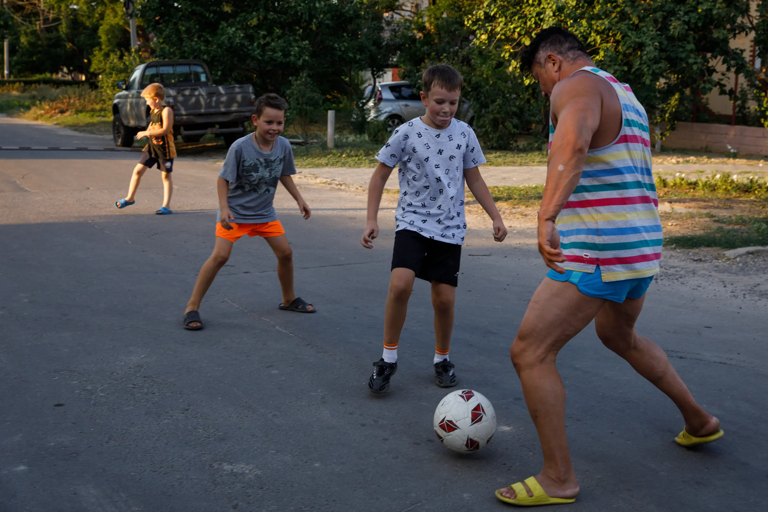 Anna Kurkurina plays soccer with several neighborhood children on the street outside her home.