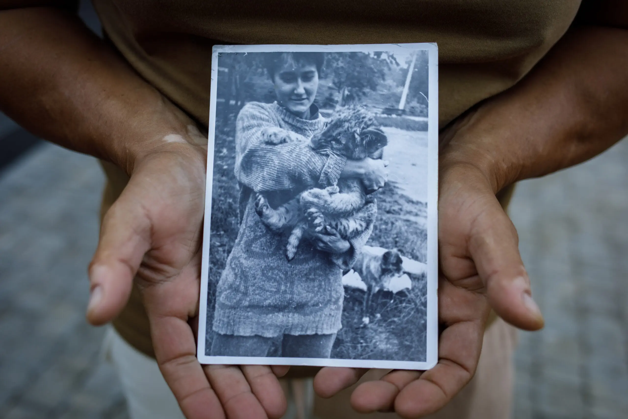 Anna Kurkurina holds a picture of herself with a lion cub at the Mykolaiv Zoo in 1995.